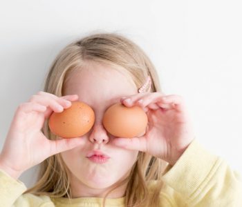 Kinder vegetarisch ernähren: Mädchen mit Eiern vor den Augen