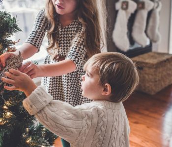 Kinder schmücken einen Baum als Weihnachtsritual