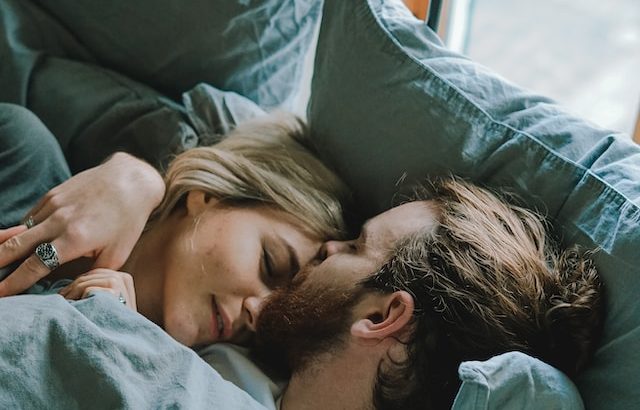 Paar kuschelt im Bett - Beitragsbild zum Thema sichere Verhütung in der Stillzeit