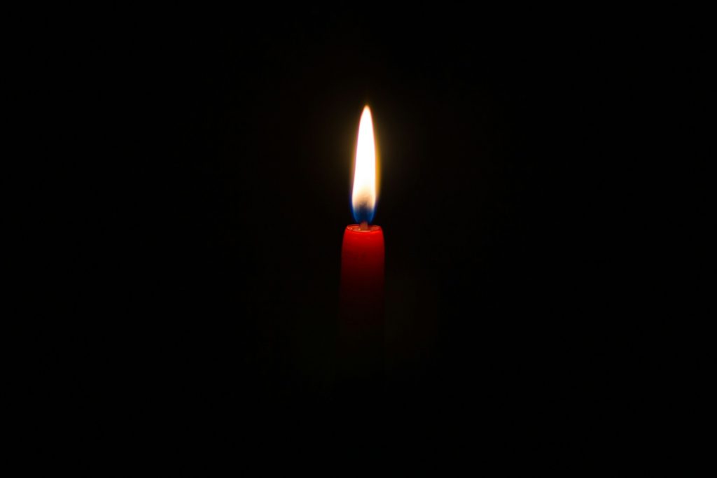 Bild einer brennenden Kerze vor schwarzem Hintergrund. Zum Thema: Missed Abortion