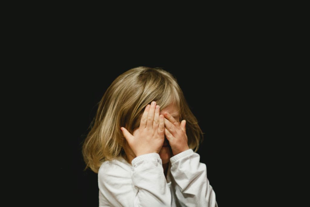ADS und ADHS bei Säuglingen und Kleinkindern - Kind versteckt Gesicht hinter den Händen